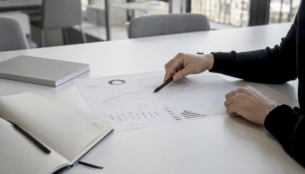 Hands carefully examine a printed dashboard containing SEO data.